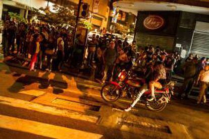 Transeúntes circulan por una calle, el pasado lunes 2 de diciembre de 2013, durante un corte de energía eléctrica en Caracas (Venezuela). EFE/Archivo