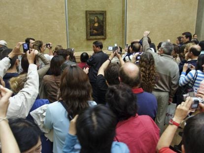 Una multitud rodea y fotografía 'La Gioconda' de Leonardo Da Vinci, en el Museo del Louvre, París.