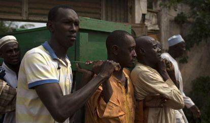 Hombres portan los f&eacute;retros de dos hombres asesinados en Bangui.