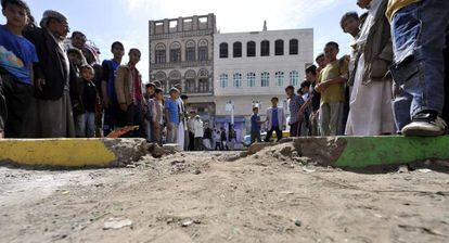 Varios curiosos congregados en el lugar donde hizo explosión un artefacto en Saná (Yemen).