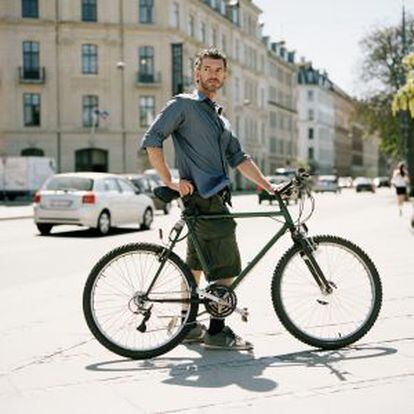 Un hombre lleva su bicicleta por Copenhague.