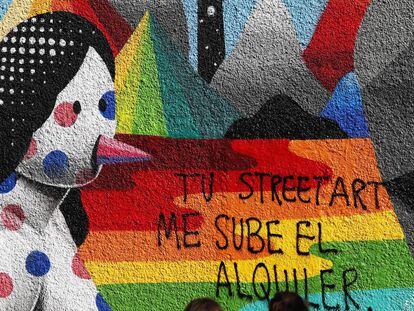 Pintada contra la gentrificación sobre un grafiti de Okuda, en la calle de Embajadores de Madrid.