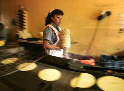 Una trabajadora recoge tortillas recién horneadas en una tienda de la ciudad de México.