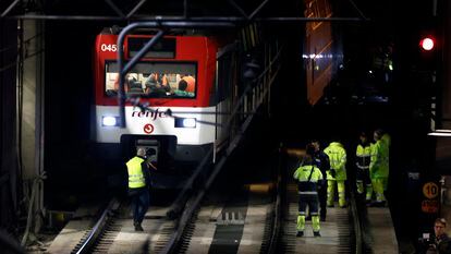 Varios operarios junto al tren de Cercanías que descarriló este martes en la entrada de la madrileña estación de Atocha.