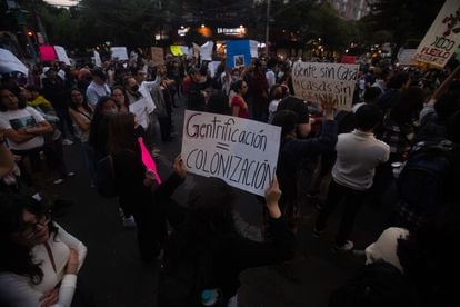 A young woman holds a sign with the phrase "Gentrification = Colonization"during a protest in Mexico City against gentrification, on November 17, 2022. 