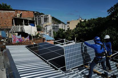 Trabajadores de la organización sin fines de lucro Revolusolar instalan paneles solares en una favela en Río de Janeiro (Brasil), el pasado 1 de marzo.