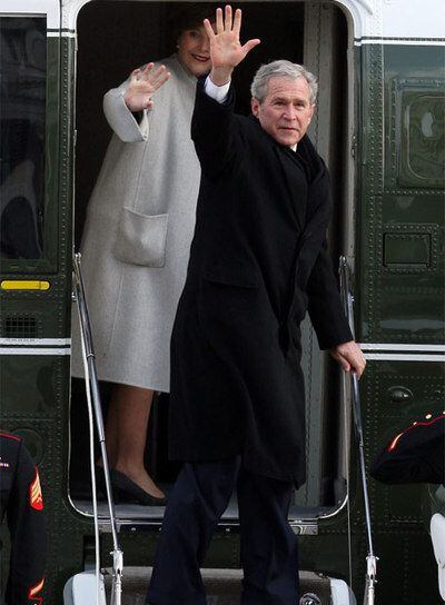 Bush y su esposa suben saludan desde el helicóptero en el que abandonan el Capitolio tras la ceremonia de investidura.