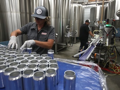 Una empleada de Can Van coloca latas de aluminio vacías en una cinta transportadora en San Carlos, California.