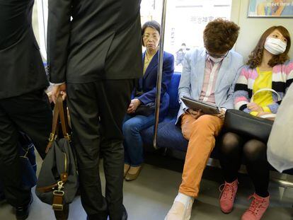 J&oacute;venes sentados en el metro de Tokio, Jap&oacute;n.
 