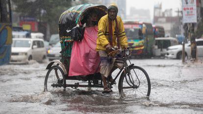 Commuters drive through waterlogged street in Dhaka as it drizzled all day due to cyclone jawad in Dhaka on December 6, 2021. (Photo by Ahmed Salahuddin/NurPhoto via Getty Images)