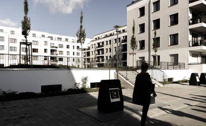 Una mujer pasa junto a un complejo residencial en Berlín.