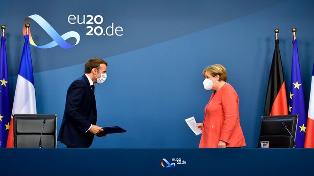 TOPSHOT - German Chancellor Angela Merkel (R) and French President Emmanuel Macron (L) leave after their joint video press conference at the end of the European summit at the EU headquarters in Brussels on July 21, 2020. - EU leaders approved a 750-billion-euro package to revive their coronavirus-ravaged economies after a tough 90-hour summit on July 21, along with a trillion-euro budget for the next seven years. (Photo by JOHN THYS / POOL / AFP)