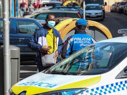 Un policía municipal informa a un vecino en las zonas confinadas del barrio carabanchelero de Vistalegre, en Madrid.