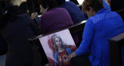 Una mujer reza en la iglesia de la Virgen de Caacup&eacute;, Buenos Aires.