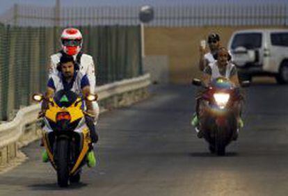 Un operario traslada a un piloto durante el Gran Premio de motociclismo de Bahrein.