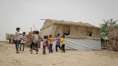 Un grupo de niños desplazados en Yemen juega junto a un refugio de emergencia.