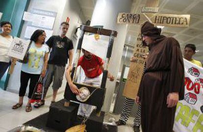 Miembros de la Plataforma de Afectados por la Hipoteca realizan una 'performance' en una oficina de Bankia.