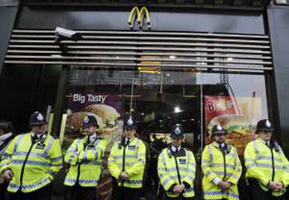 La policía británica proteje un McDonalds durante la manifestación convocada por la Confederación británica de sindicatos (TUC, siglas en inglés), en Londres (Reino Unido) hoy, sábado 20 de octubre de 2012 contra los recortes impuestos por el Gobierno de David Cameron y defendió una política alternativa a las medidas de austeridad.