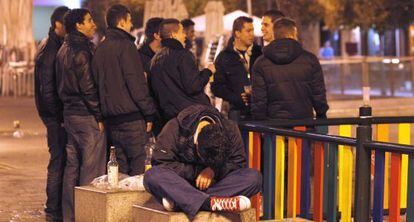 Un grupo de j&oacute;venes bebe en un parque de Madrid.