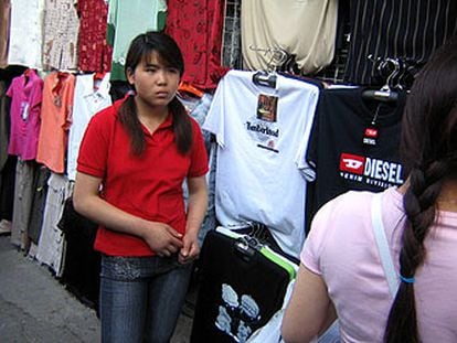 Una vendedora china en un puesto de ropa falsificada en un mercadillo de Pekín.