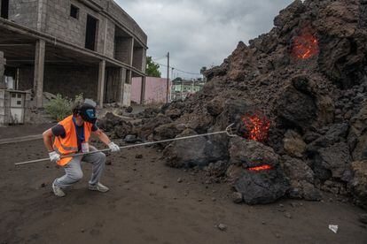 Un técnico del Instituto Volcanológico de Canarias (INVOLCAN) extrae una muestra de roca volcánica procedente de la colada de lava a su llegada a la localidad de Todoque, este miércoles.