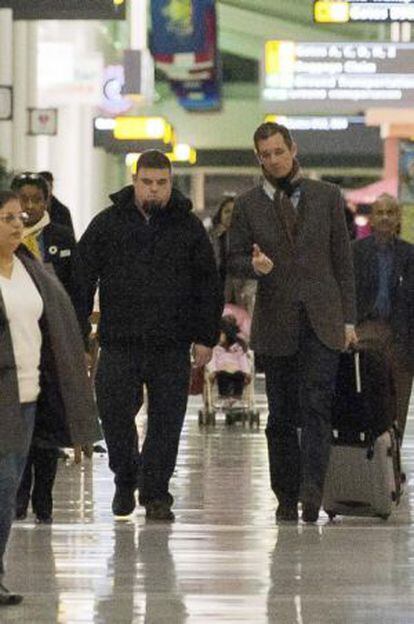 El duque de Palma, Iñaki Urdangarin, junto a un policía judicial en el aeropuerto de Washington, el 3 de enero de 2012.