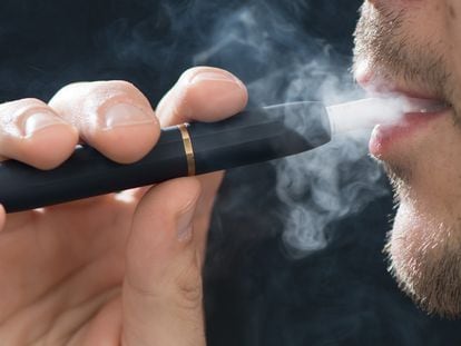 Un hombre fuma el calentador de tabaco IQOS de Philip Morris.