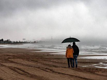 Dos personas caminan este viernes por la playa de la Malvarrosa de Valencia.