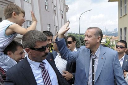 Recep Tayyip Erdogan saluda a un niño después de votar en Estambul.