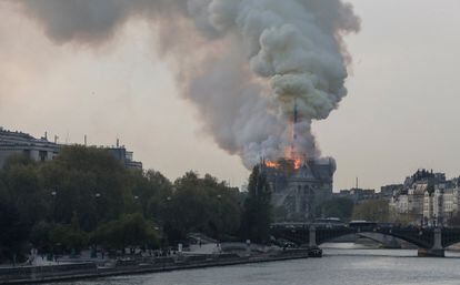 La columna de fum, visible a quilòmetres de distància, s'eleva sobre la catedral, erigida al costat del riu Sena.