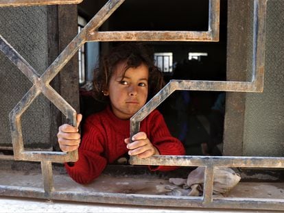 Una niña siria desplazada mira a través de una ventana mientras espera con su familia en una mezquita en la ciudad de Hasaka, al noreste de Siria. Este país es el que más ayuda humanitaria recibió en 2020.