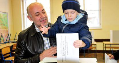 Un hombre vota con su hijo en Zagreb.