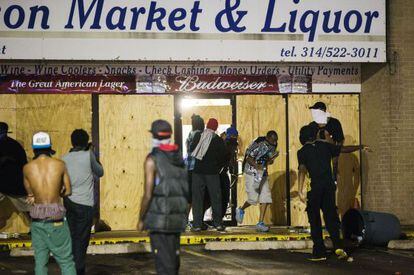 Un grupo de hombres saquean una tienda este viernes en Ferguson.