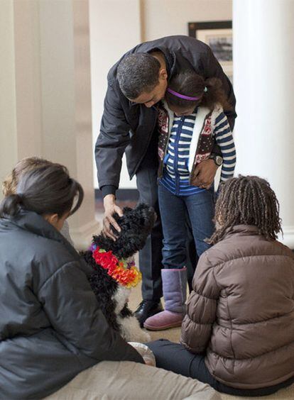 El presidente de los EE UU, Barack Obama,  junto a una de sus hijas, acaricia a Bo, el perro de agua portugués nueva mascota de la Casa Blanca.