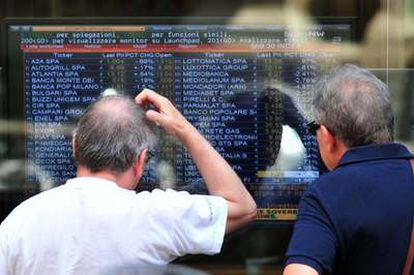 Inversores preocupados mirando las pantallas de la Bolsa de Milán