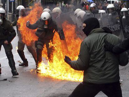 Manifestantes se enfrentan con policías antidisturbios durante una protesta con motivo de la huelga general en Atenas
