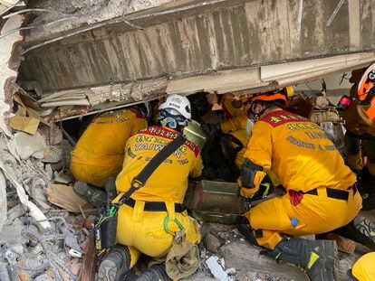 Un grupo de bomberos buscan supervivientes en el interior de un edificio derrumbado tras el terremoto, este miércoles en la ciudad taiwanesa de Hualien. 