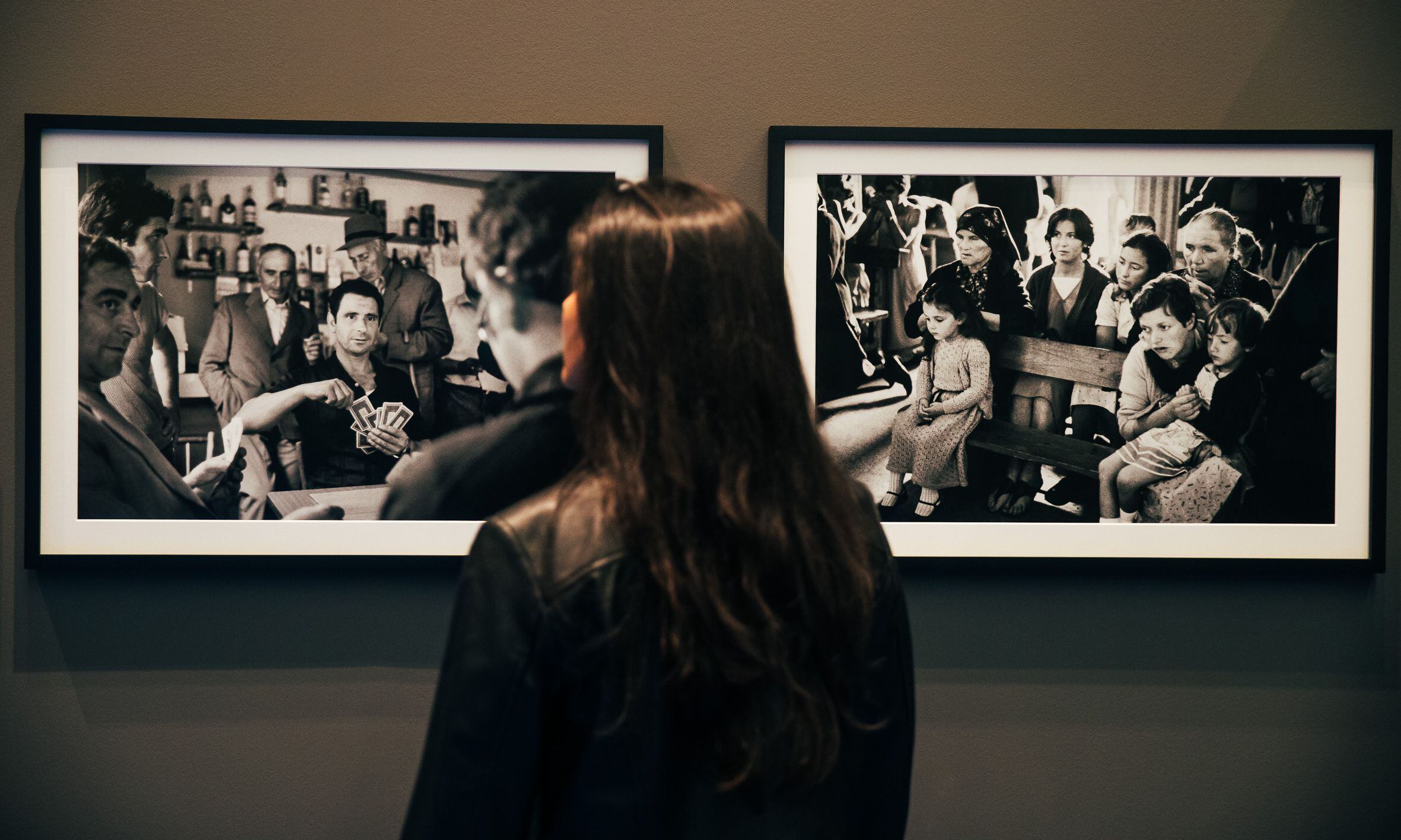 Una mujer frente a dos fotografías de la exposición.