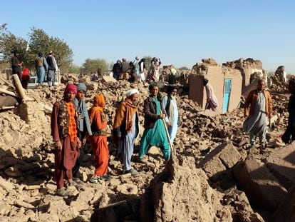 Un grupo de afganos, en medio de casas destruidas por el terremoto en el distrito de Zindah Jan, en la provincia de Herat, este domingo.