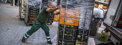 Un trabajador abastece un supermercado en Barcelona durante los primeros días del estado de alarma por el coronavirus. 